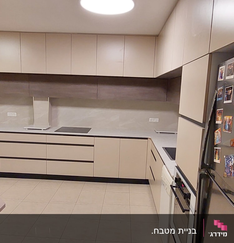 מטבח מודרני עם ארונות בהירים ומקרר עם מגנטים